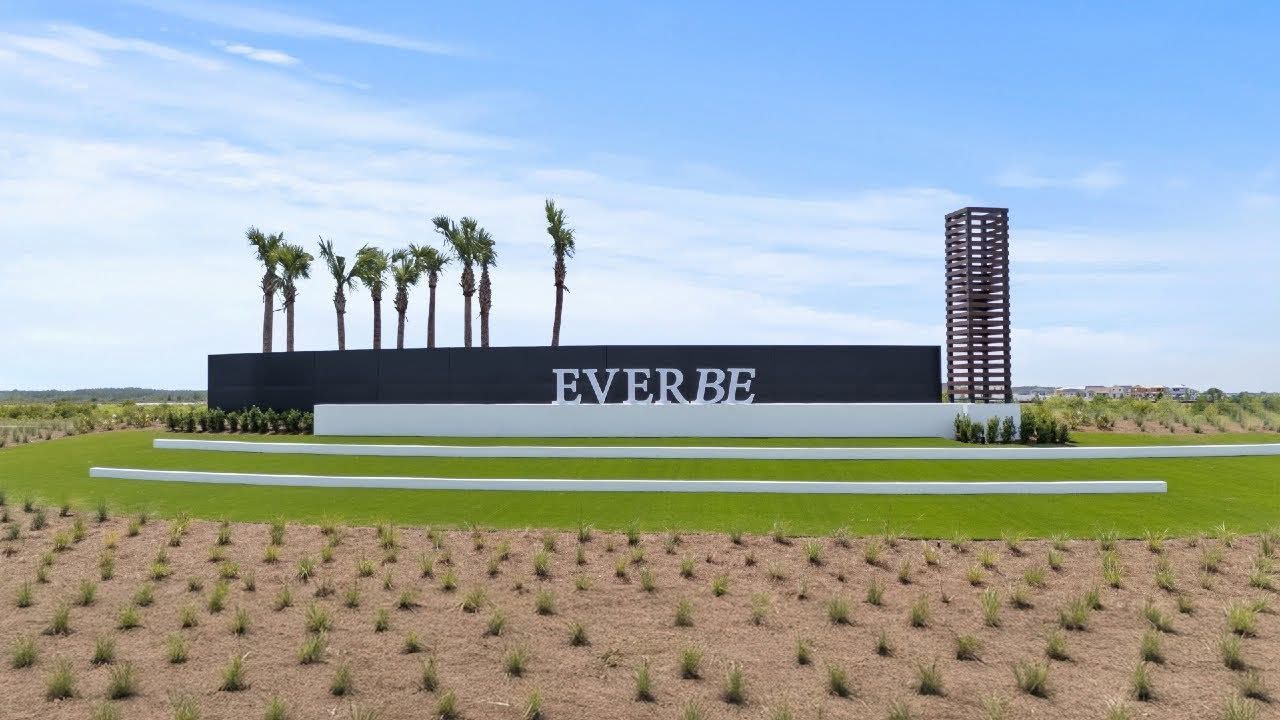Everbe sign with palm trees in a landscaped field under a blue sky