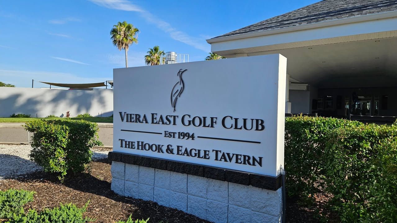Viera East Golf Club sign beside The Oak & Eagle Tavern under a sunny blue sky