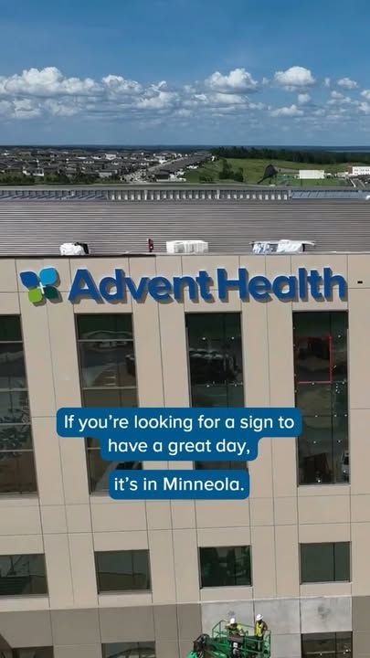 AdventHealth building with rooftop sign and a blue banner reading, “If you’re looking for a sign to have a great day, it’s in Minnesota.”