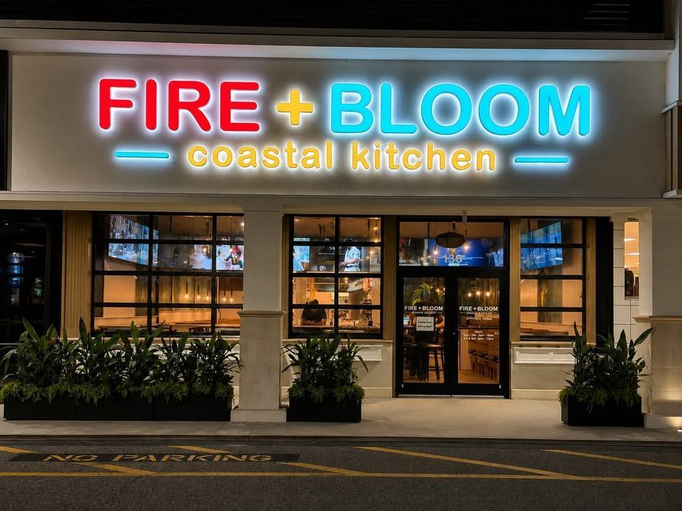 Fire + Bloom coastal kitchen restaurant storefront with neon sign at night