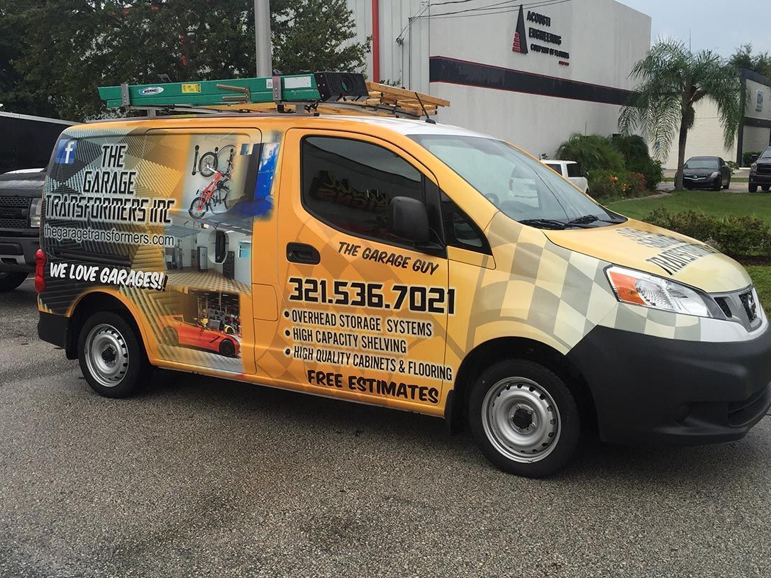 Yellow commercial van with company graphics and ladder rack parked outside a building