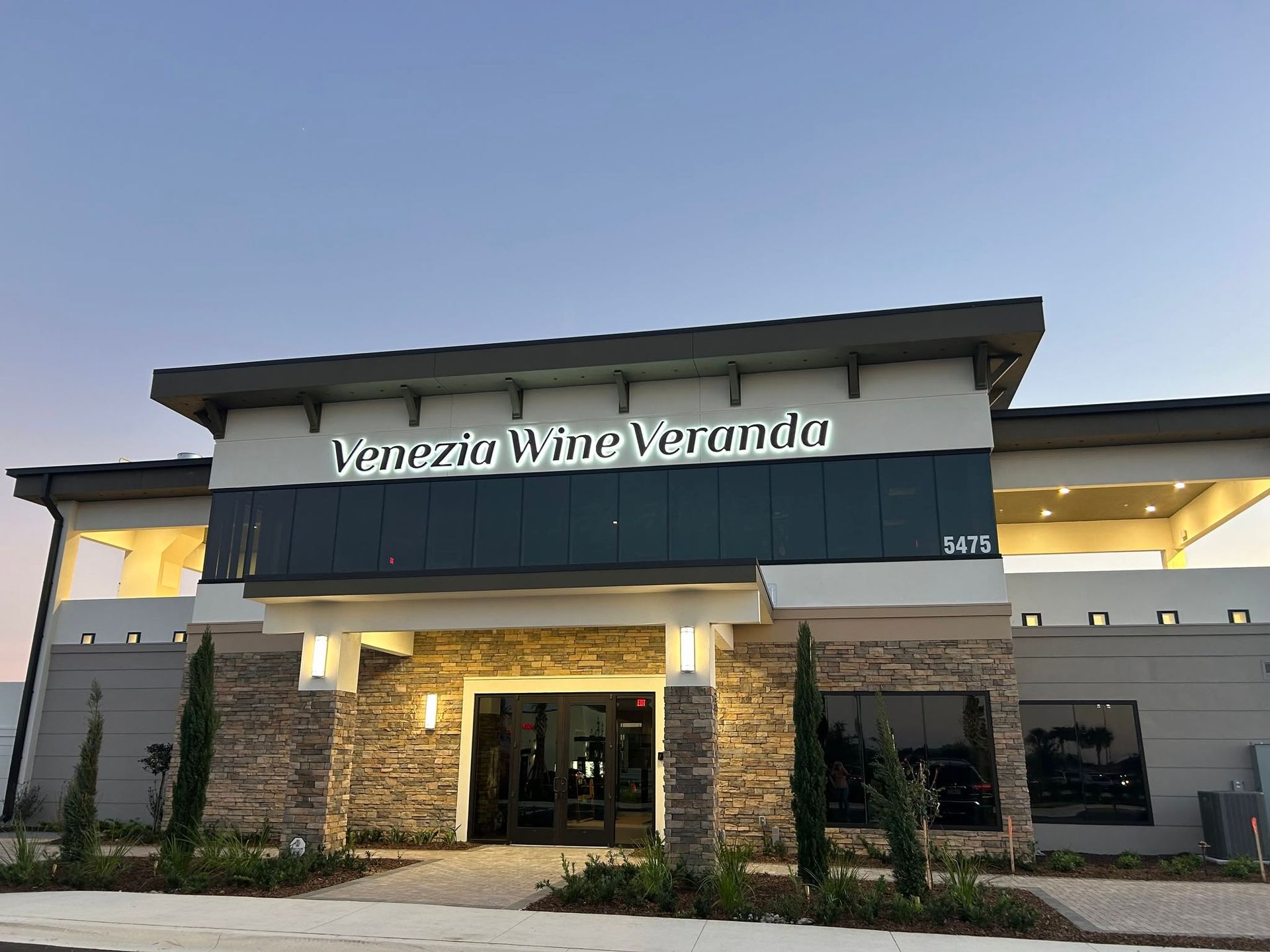 Exterior of Venezia Wine Veranda restaurant at dusk, with stone entrance and lit windows