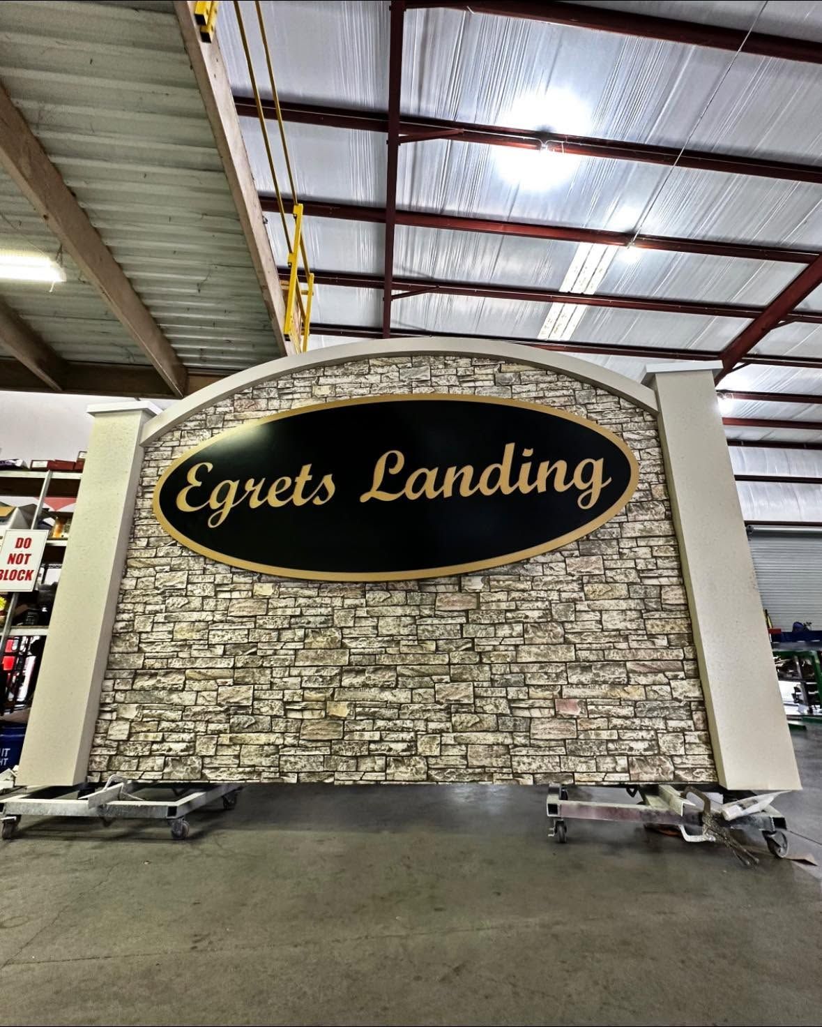 Egrets Landing sign on a stone wall inside a warehouse-like building