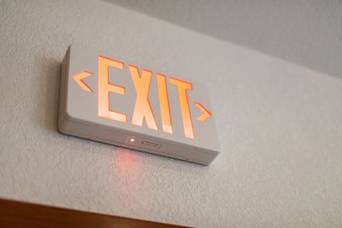 Illuminated EXIT sign mounted on a wall above a doorway