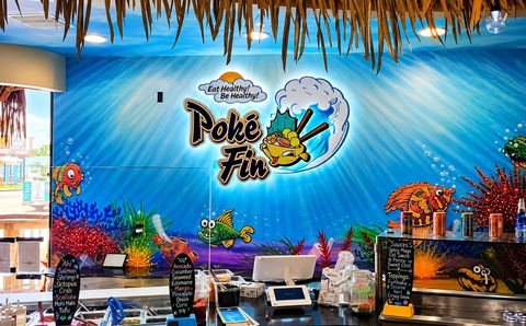 Tiki-themed restaurant mural with blue wall, palm decor, and tropical logo above a bar counter