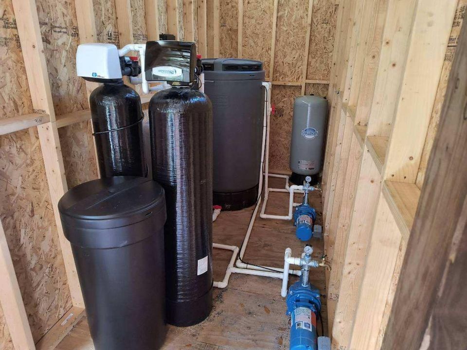 Water filtration system inside a wooden structure; includes tanks, pumps, and pipes.