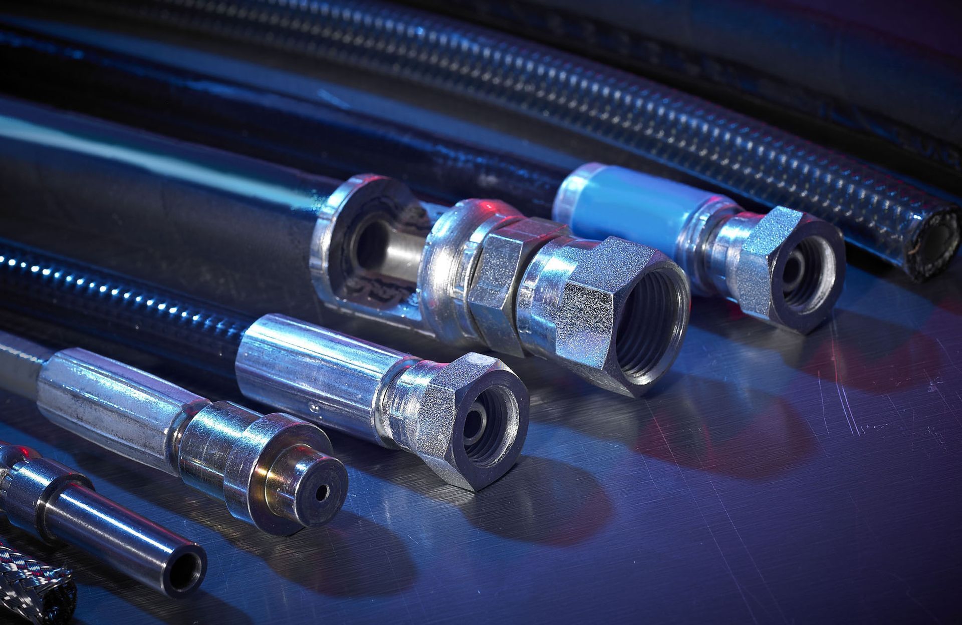 Metal cable connectors on a blue surface, lit with cool blue highlights.