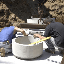 two men installing a septic tank