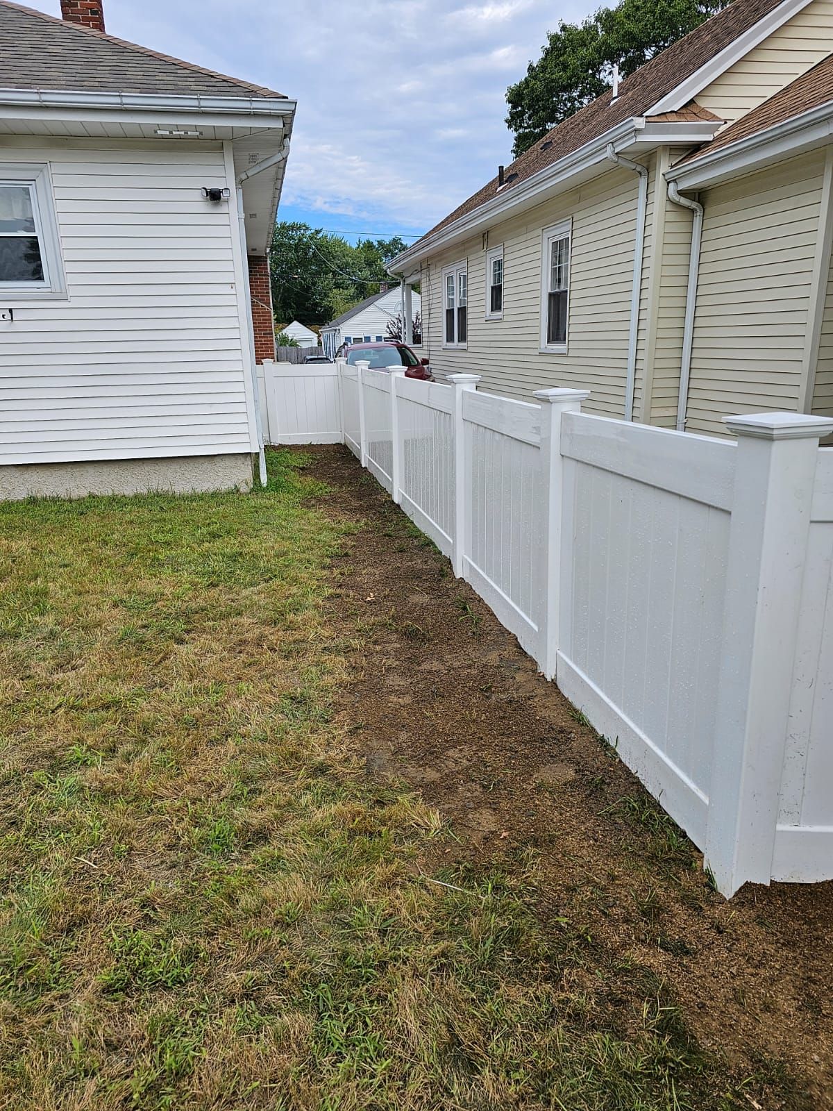 a white fence surrounds the backyard of a house