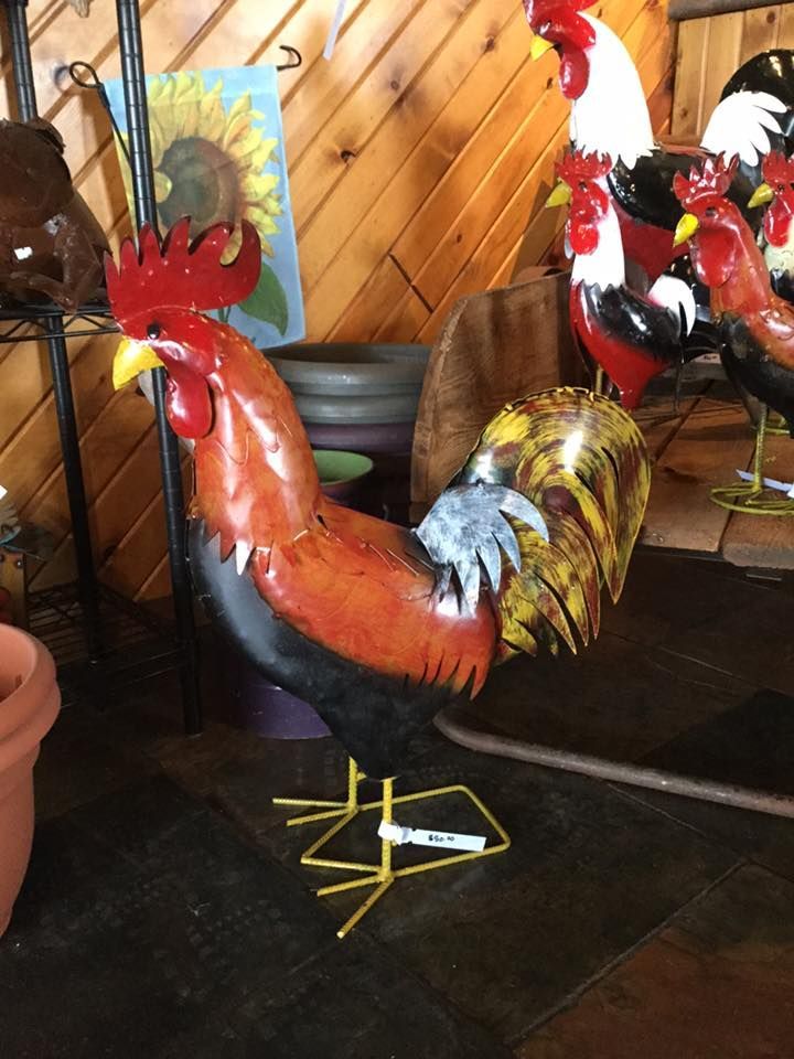 A statue of a rooster is sitting on the floor