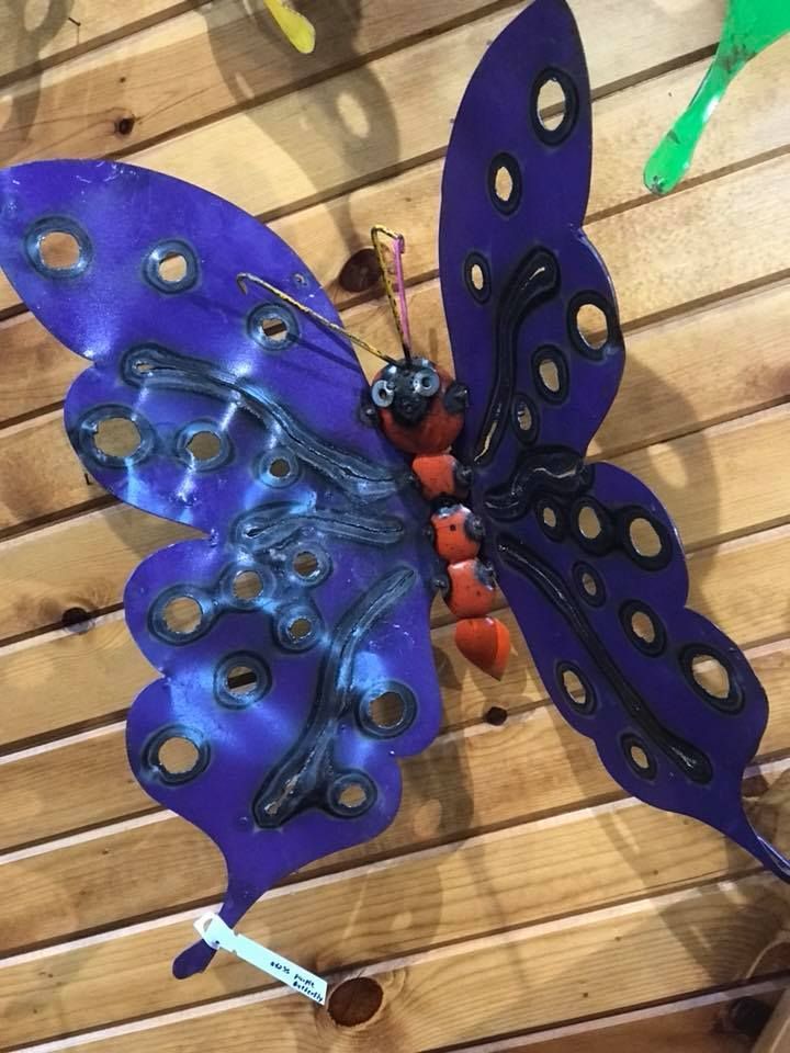 A purple butterfly is sitting on a wooden table.