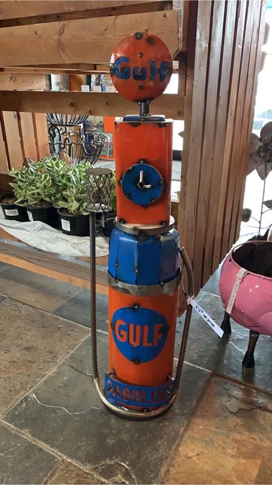 A gulf gas pump is sitting on a tiled floor in a room.