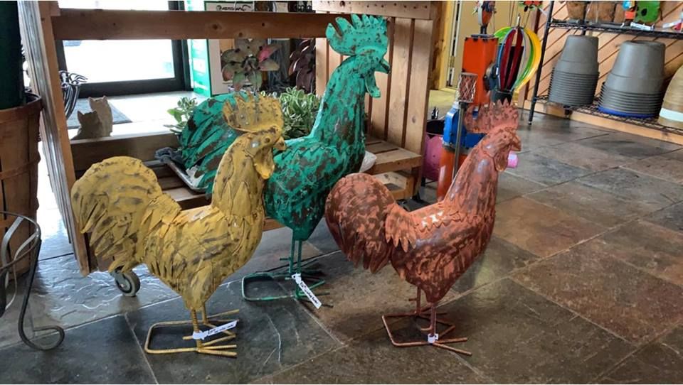 A group of roosters are standing next to each other in a room.