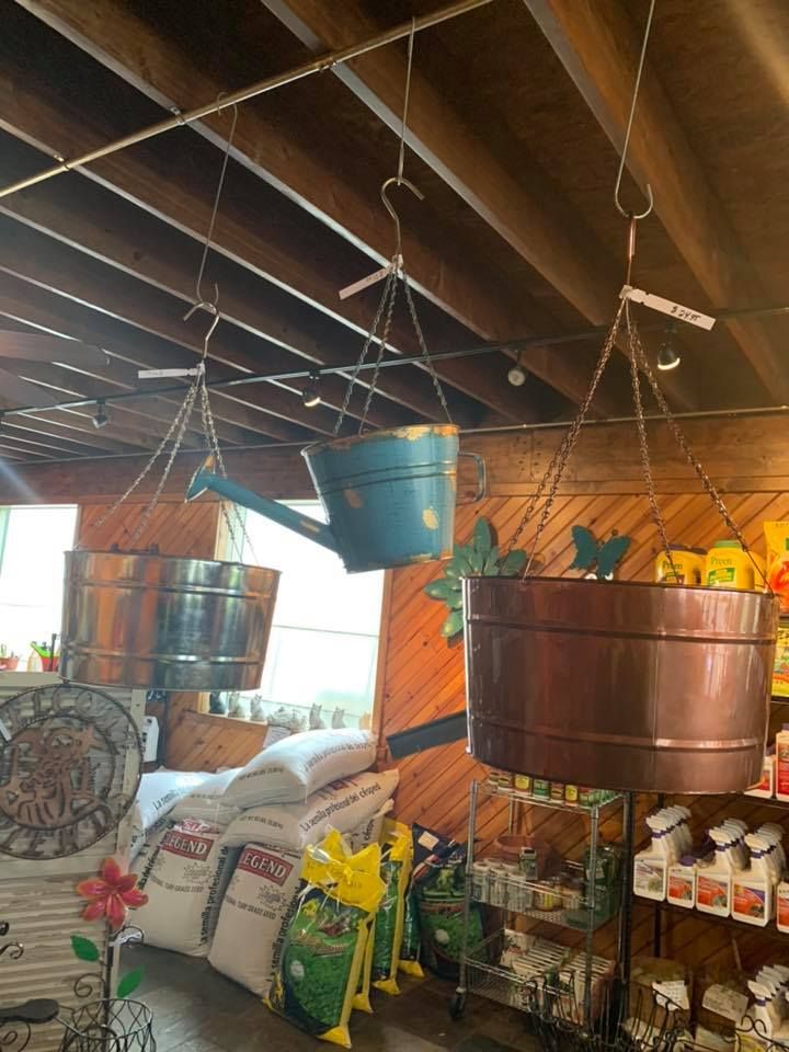 A room with a lot of pots and buckets hanging from the ceiling.