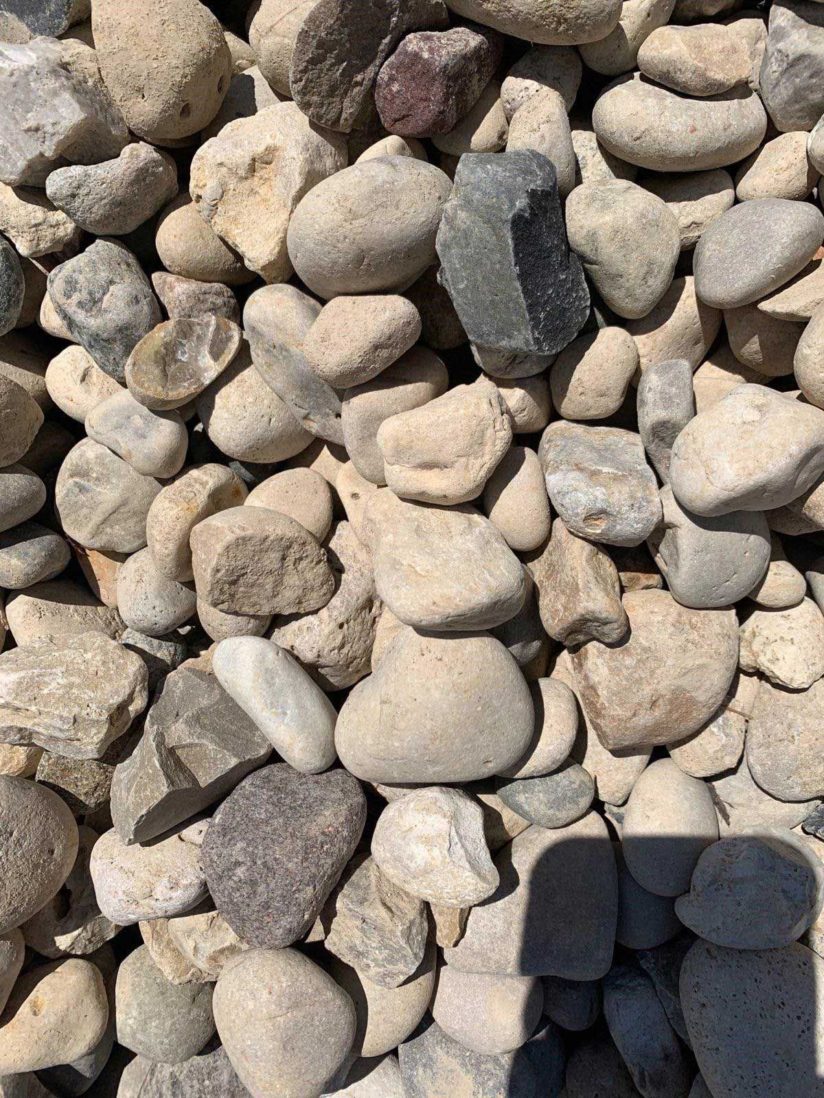A pile of rocks with a shadow on the ground.