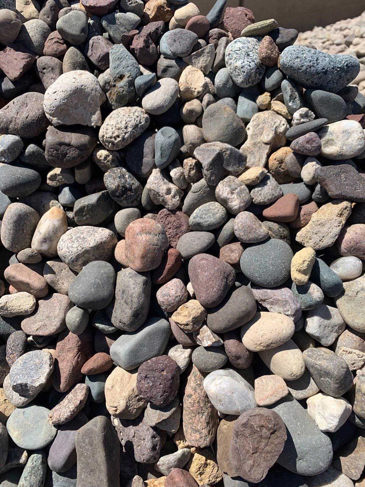 A pile of rocks of different sizes and colors sitting on top of each other.