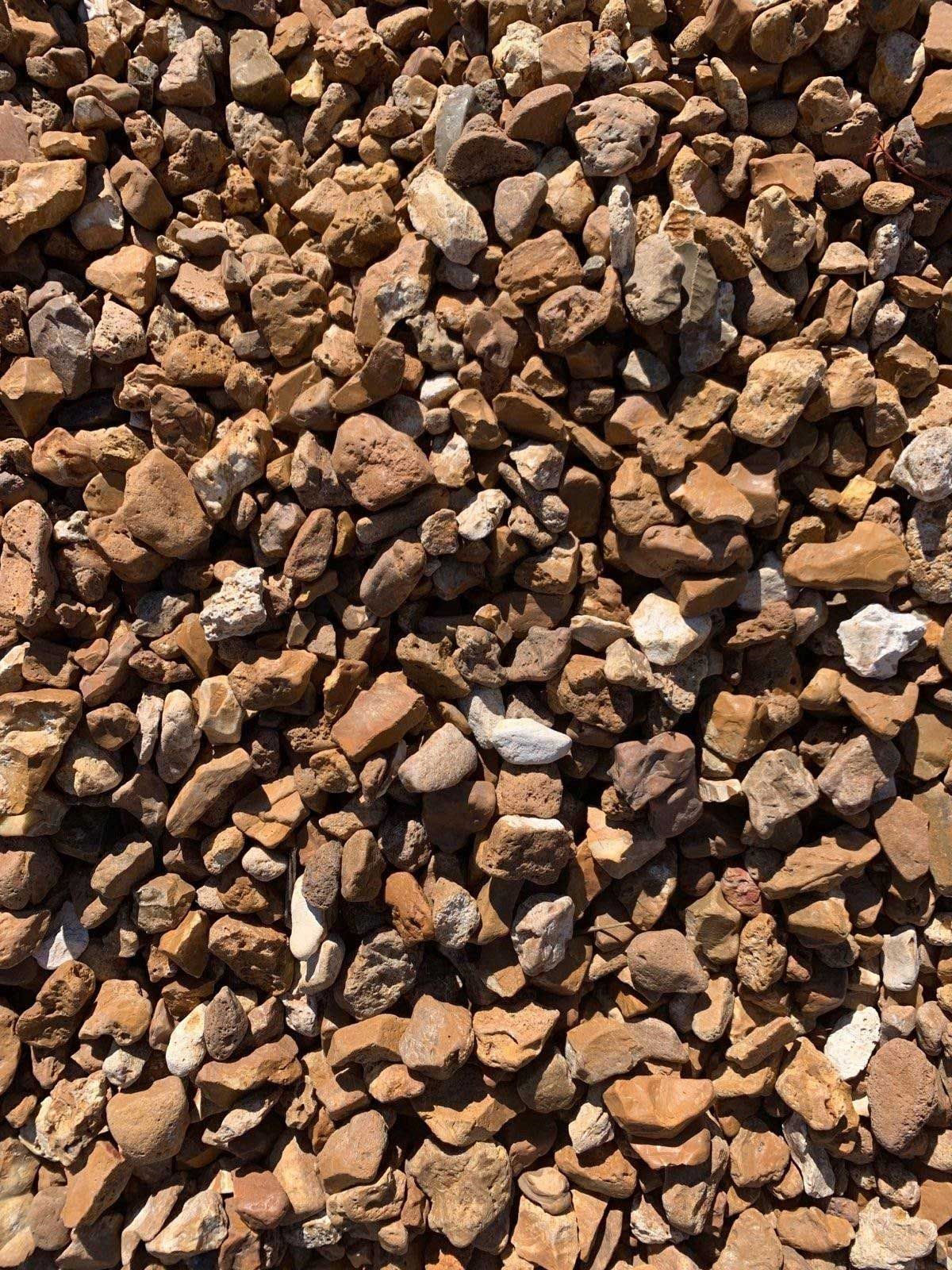 A pile of brown gravel is sitting on the ground.