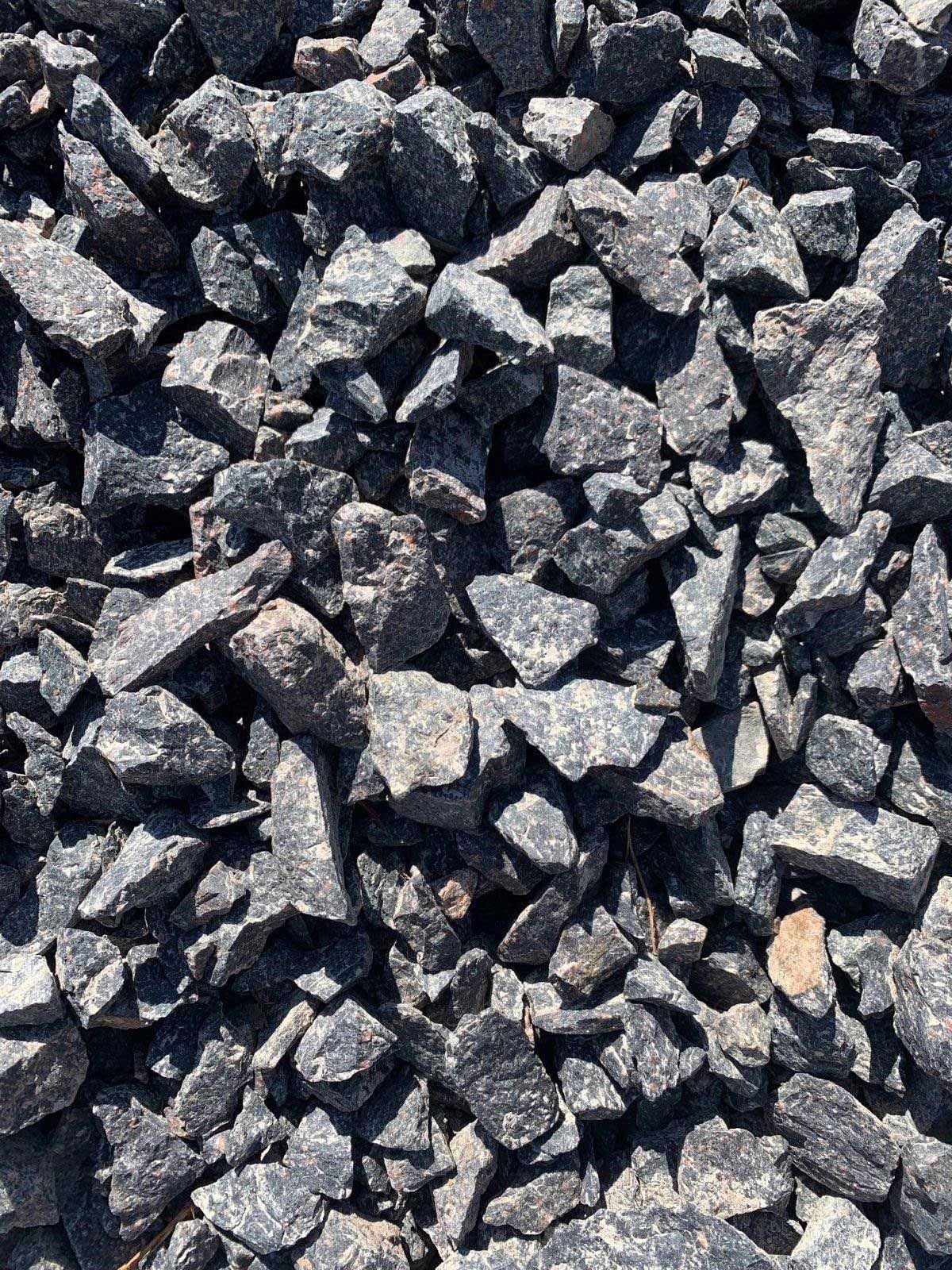 A pile of black gravel is sitting on the ground.