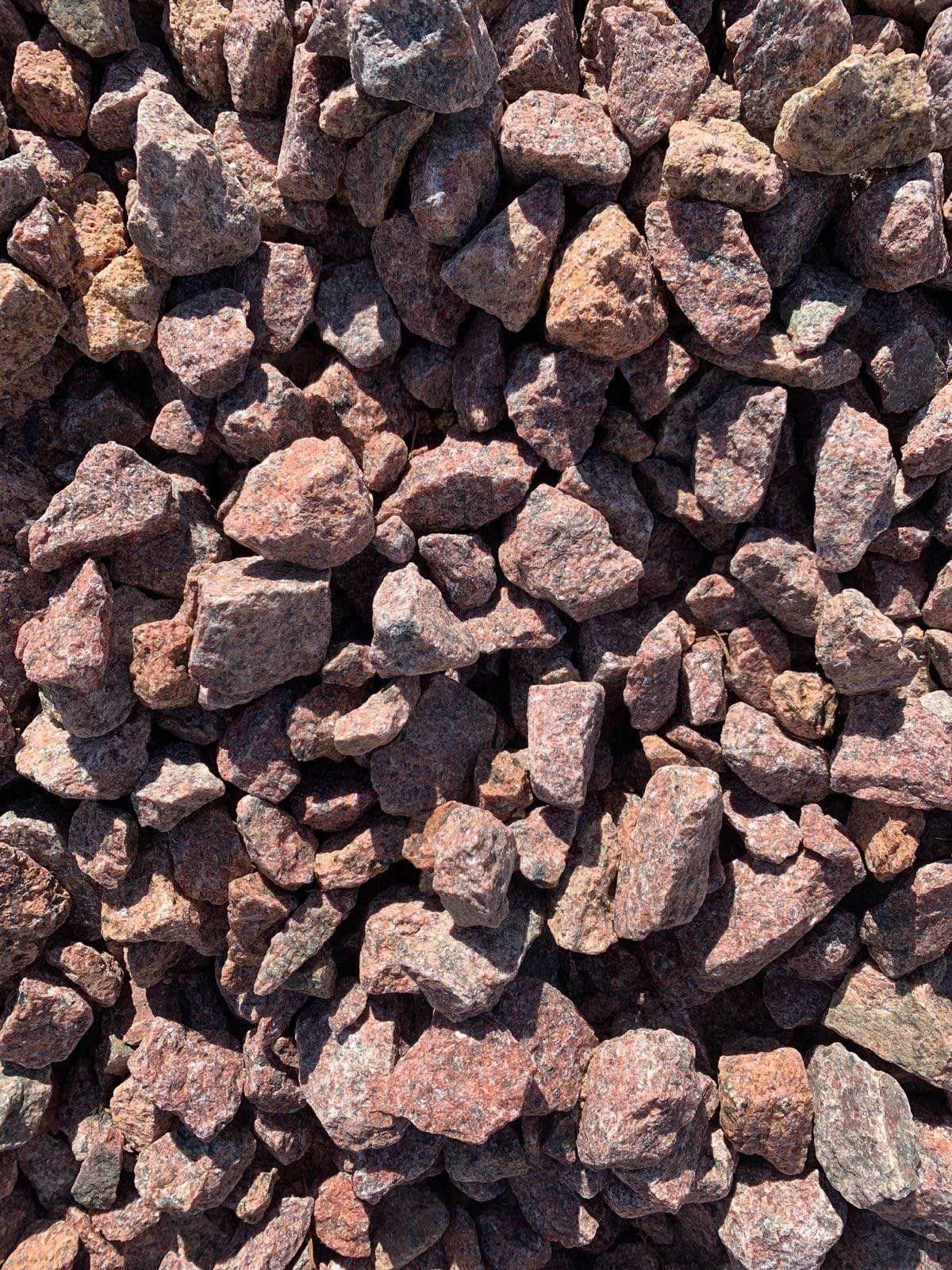A pile of red gravel is sitting on the ground.