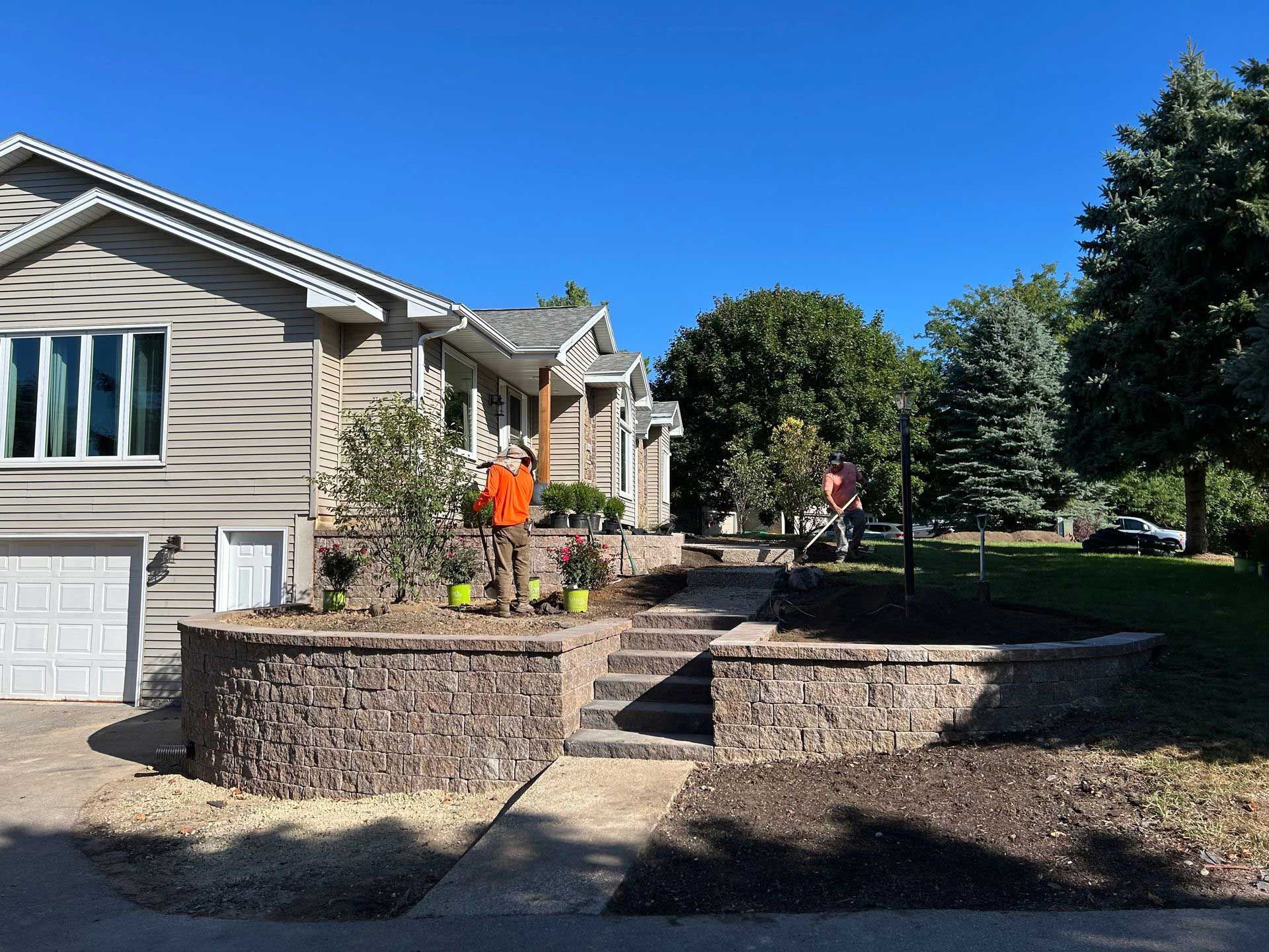 A man is standing in front of a house on a sunny day.