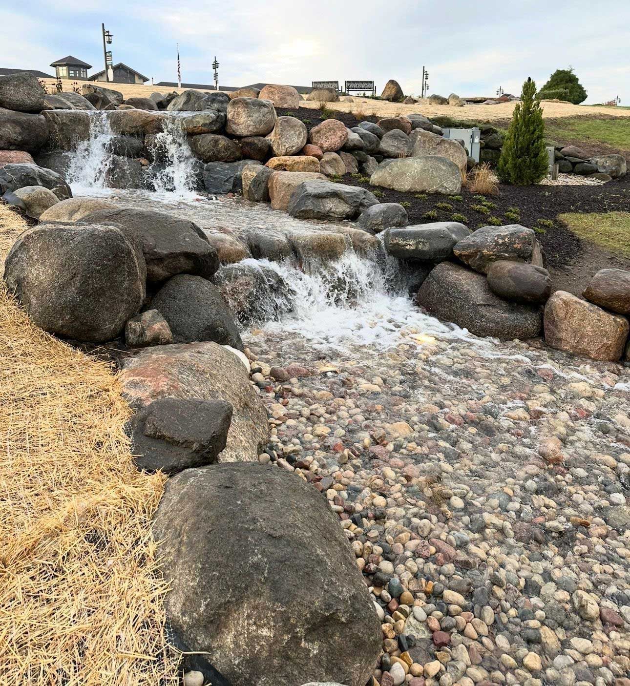 A waterfall is surrounded by rocks in a park