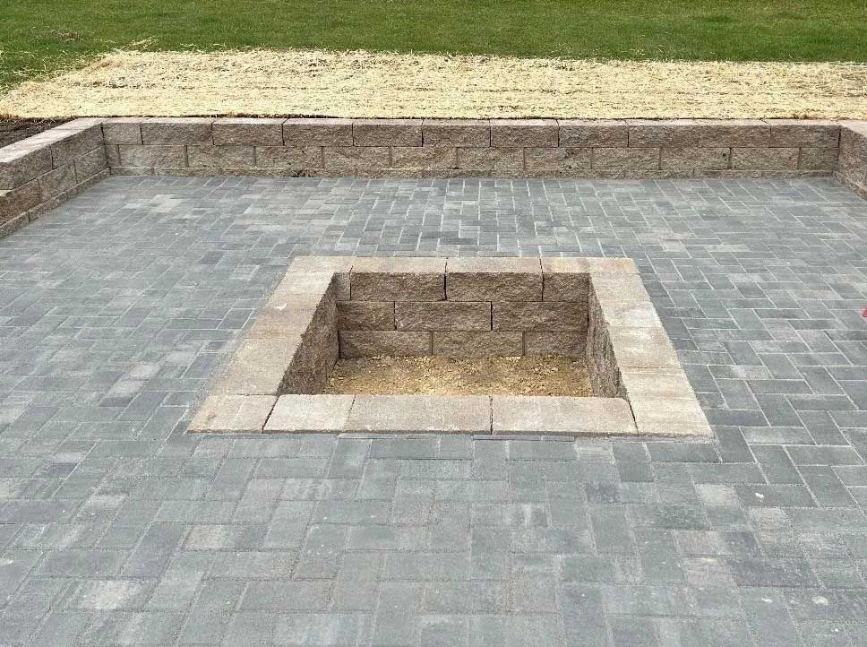 There is a fire pit in the middle of the patio.