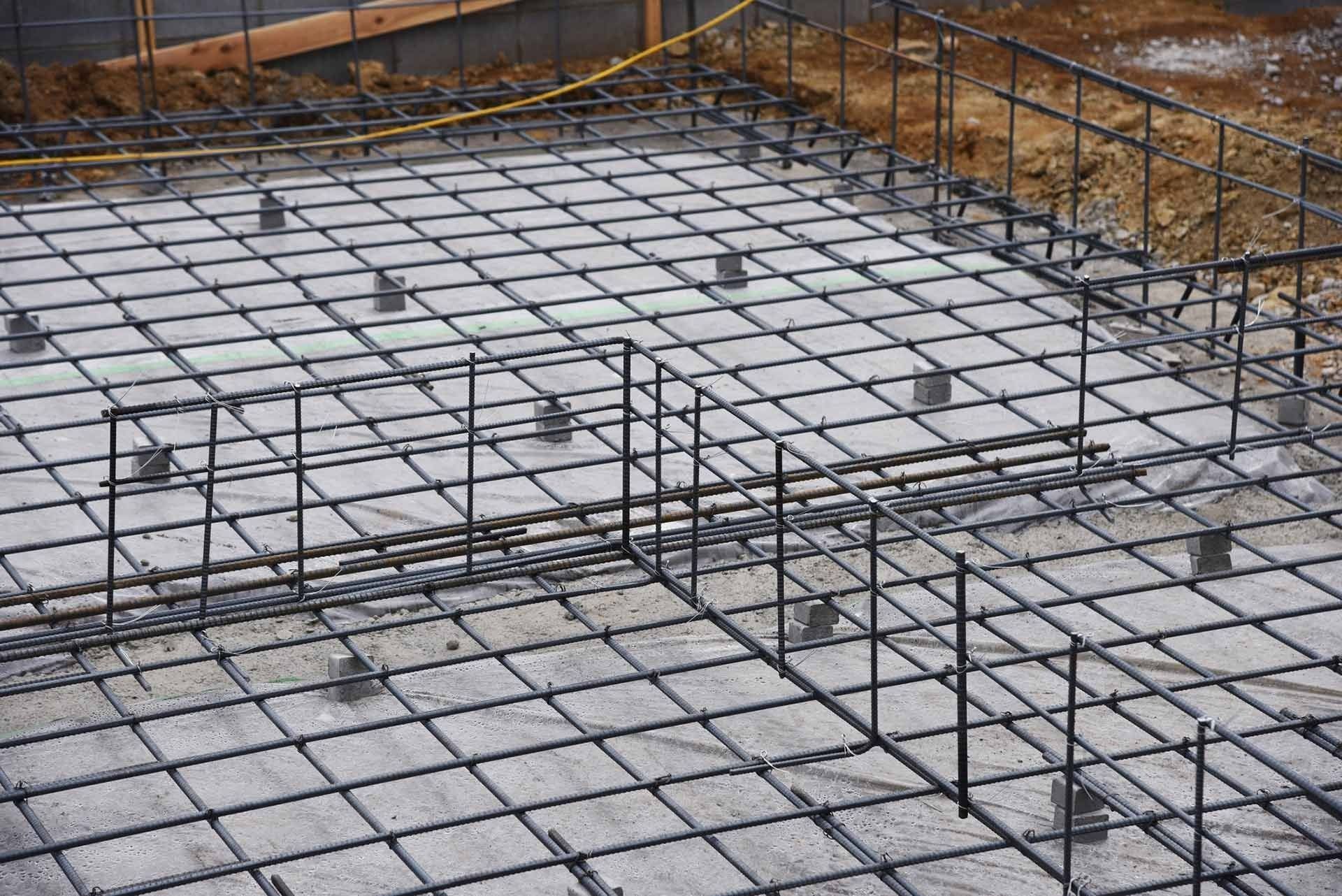 Steel reinforcement grid for concrete foundation, viewed from above.