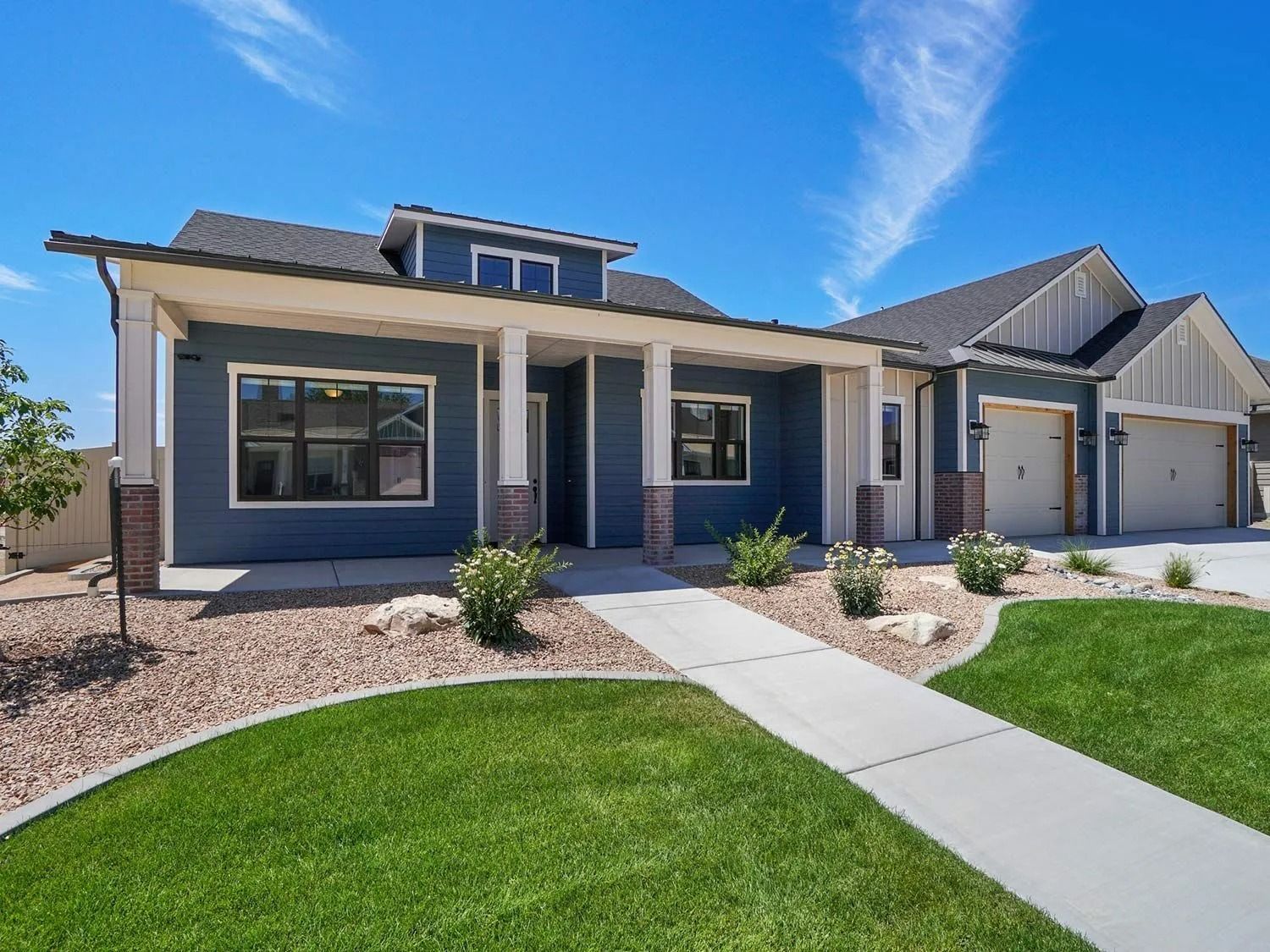 Blue house with a covered porch, white columns, and a concrete walkway.