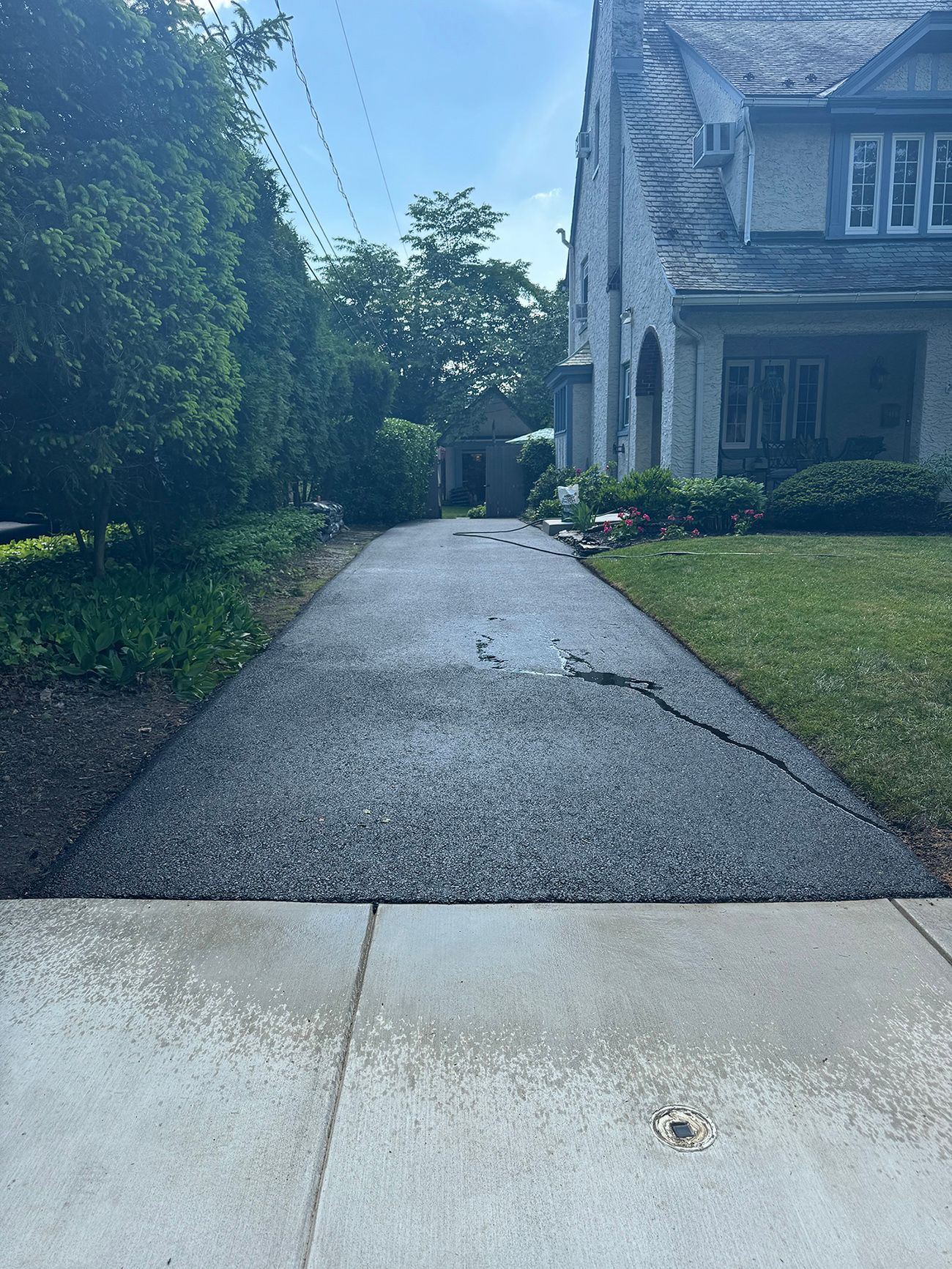 A concrete driveway leading to a large white house.