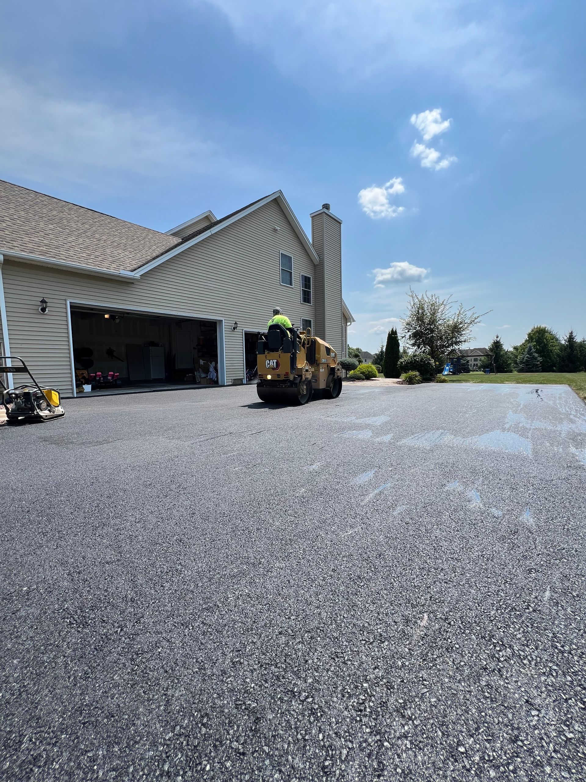 A large house with a gravel driveway in front of it.