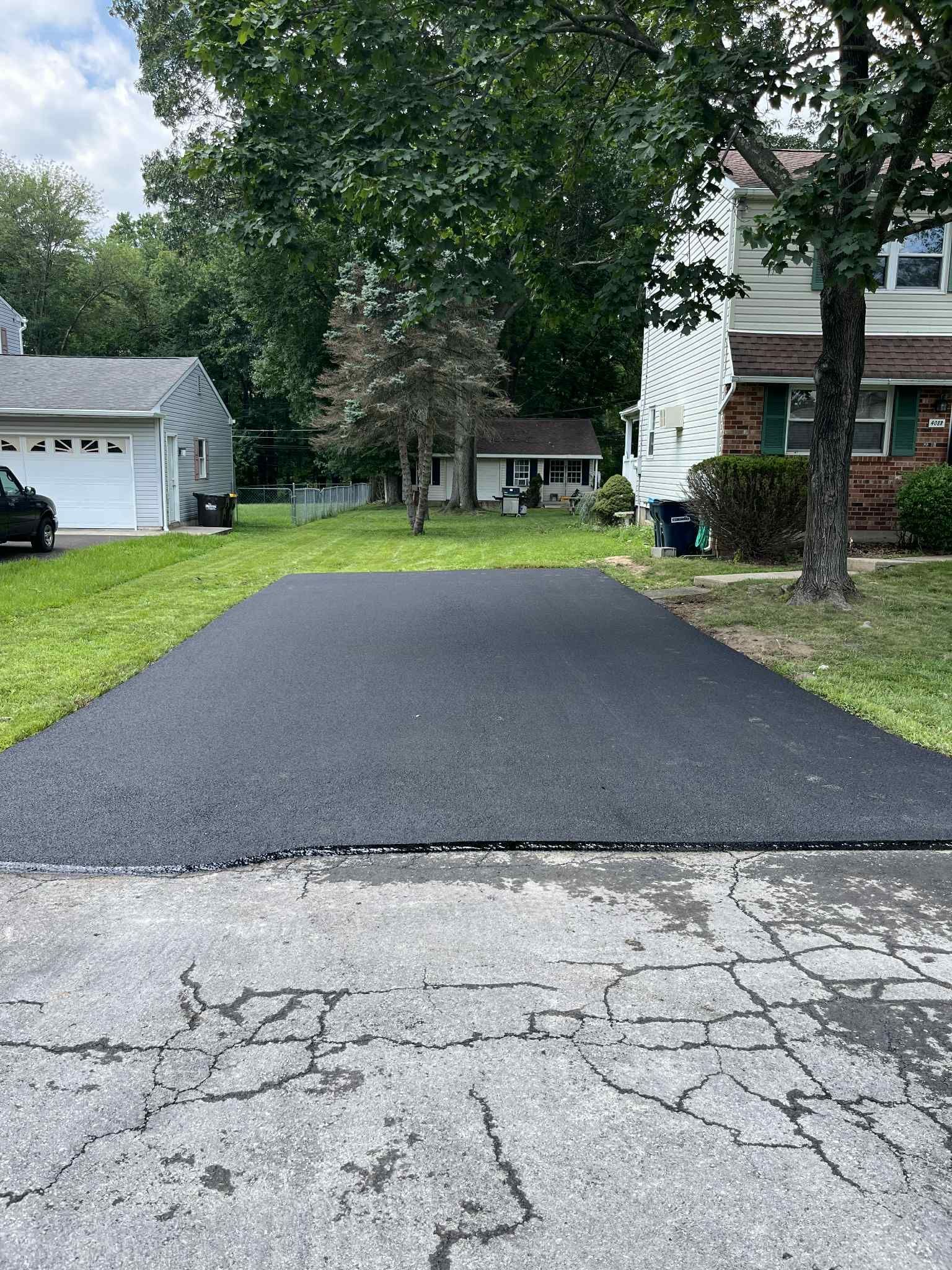 A newly paved driveway in front of a house.