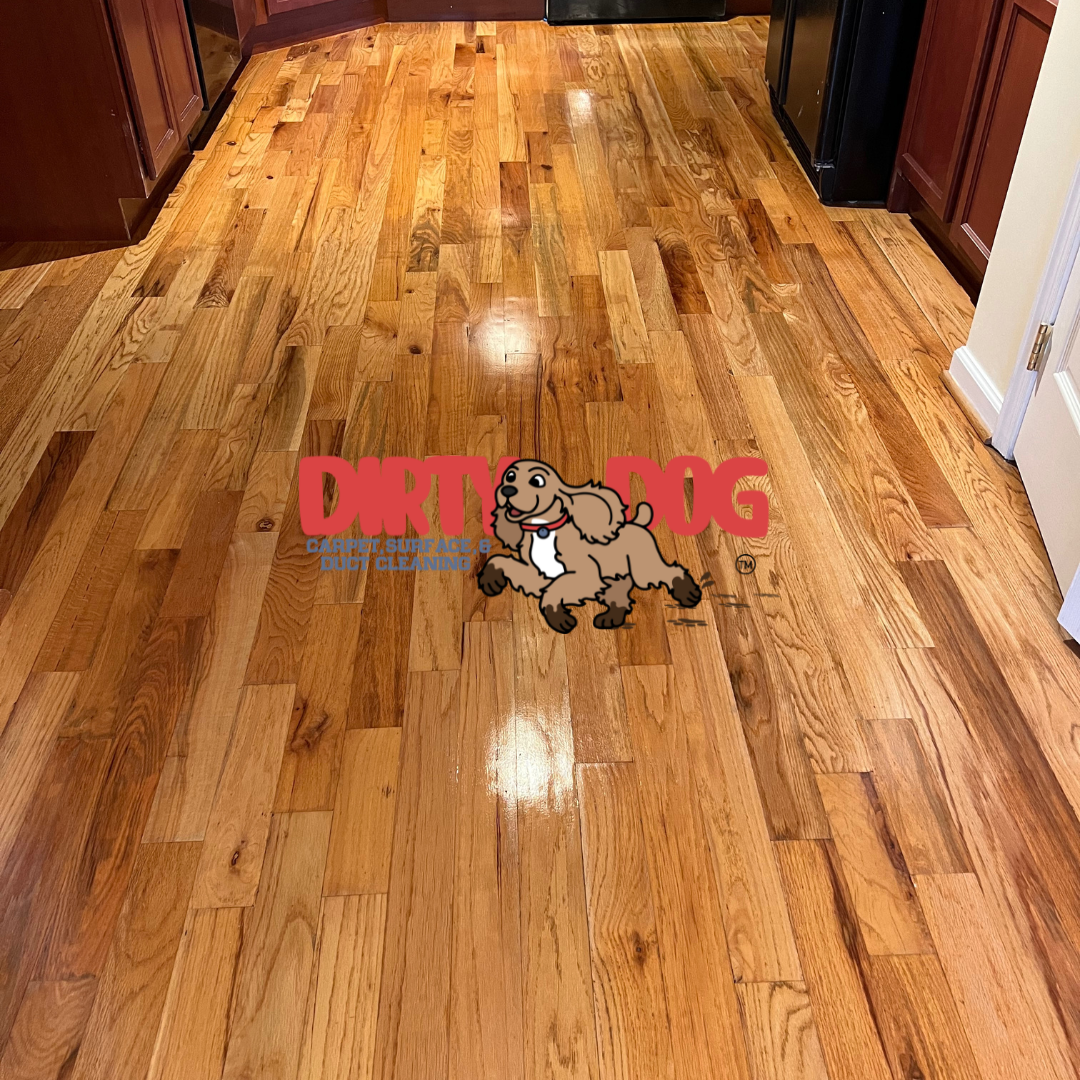 Wooden floor with light and dark brown planks, with a logo of a cartoon dog.
