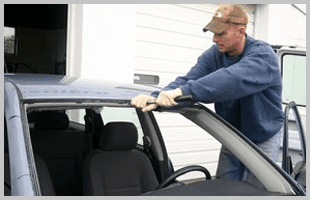 A mechanic installing a windshield