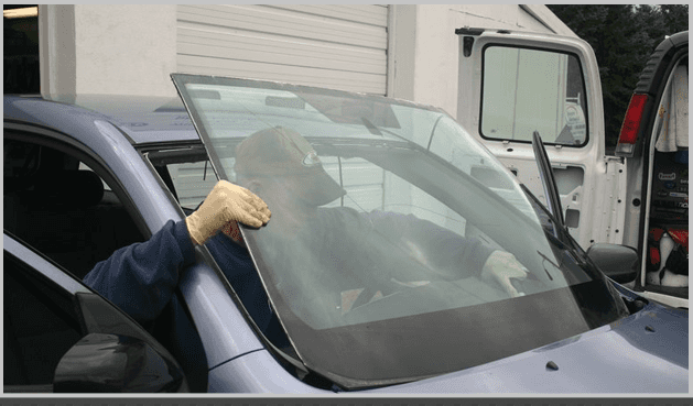A mechanic installing a windshield