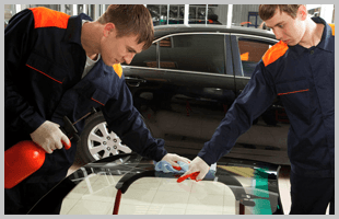 Two mechanics with a brand new windshield