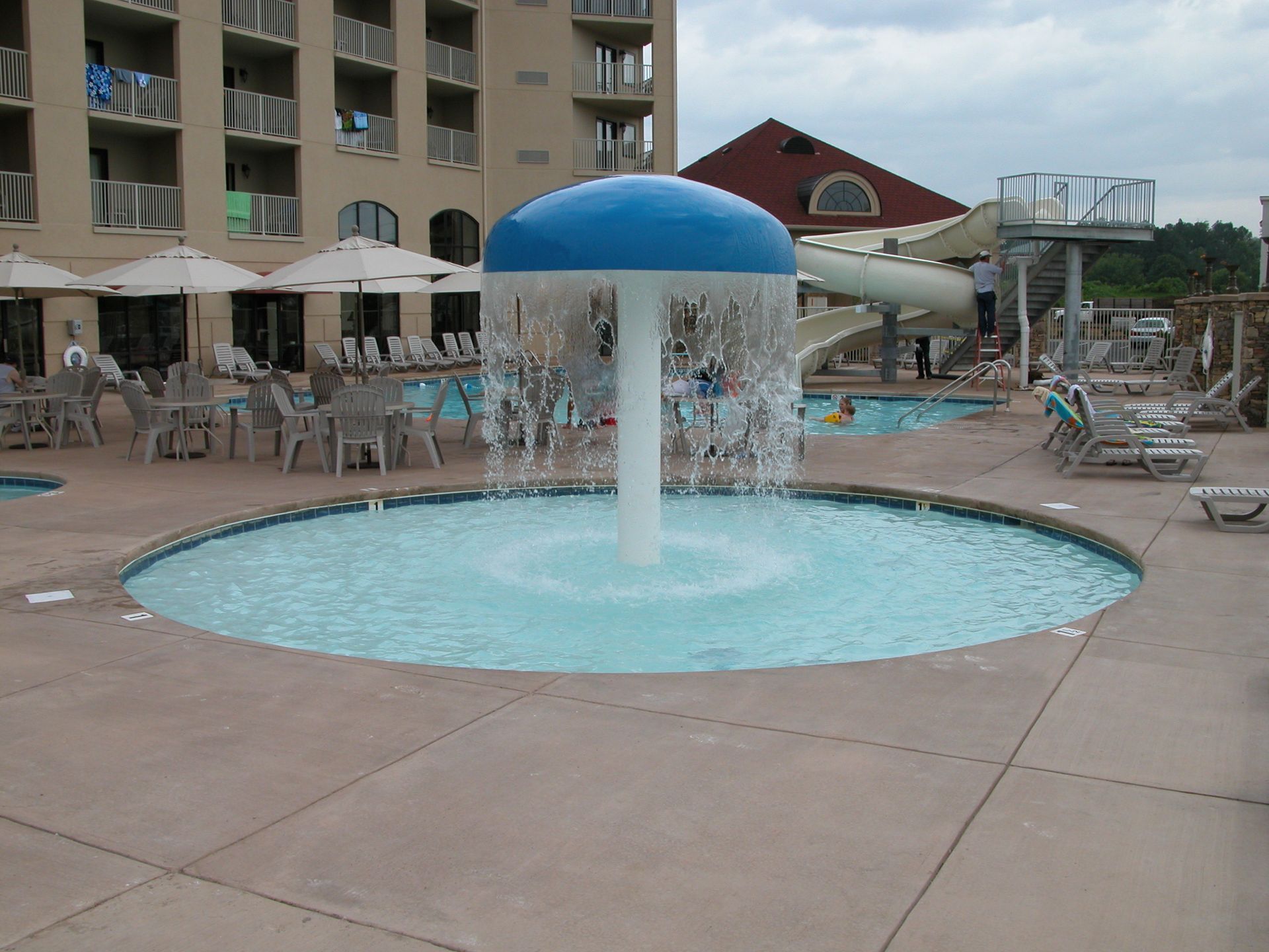 Blue-domed fountain in a hotel courtyard with lounge chairs and umbrellas around it.
