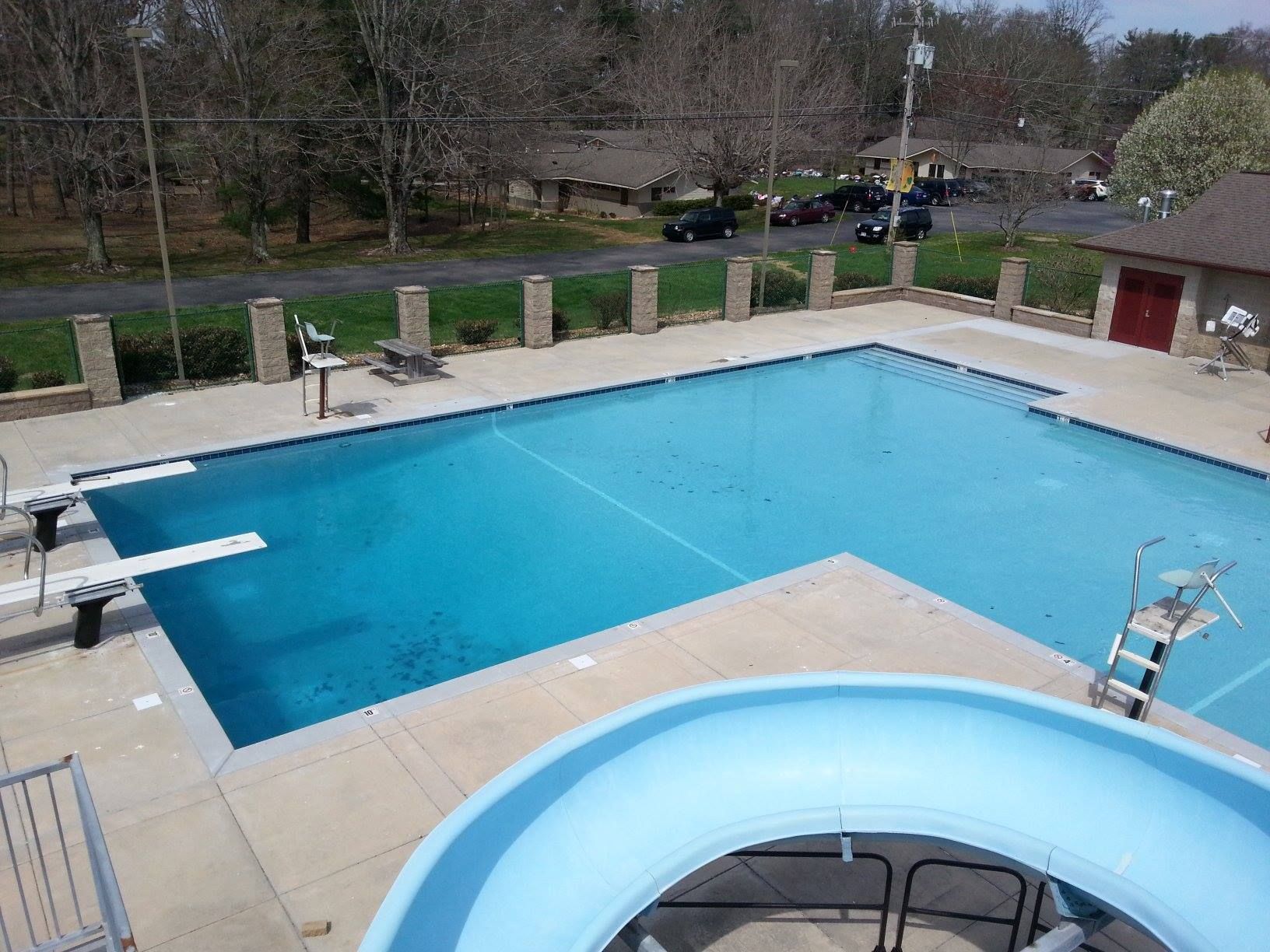Outdoor pool with diving boards and a blue inflatable ring in the foreground