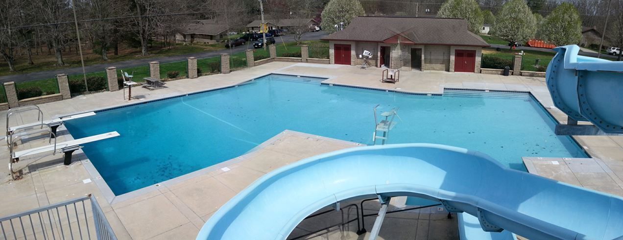 Outdoor swimming pool with blue water and a large waterslide in the foreground
