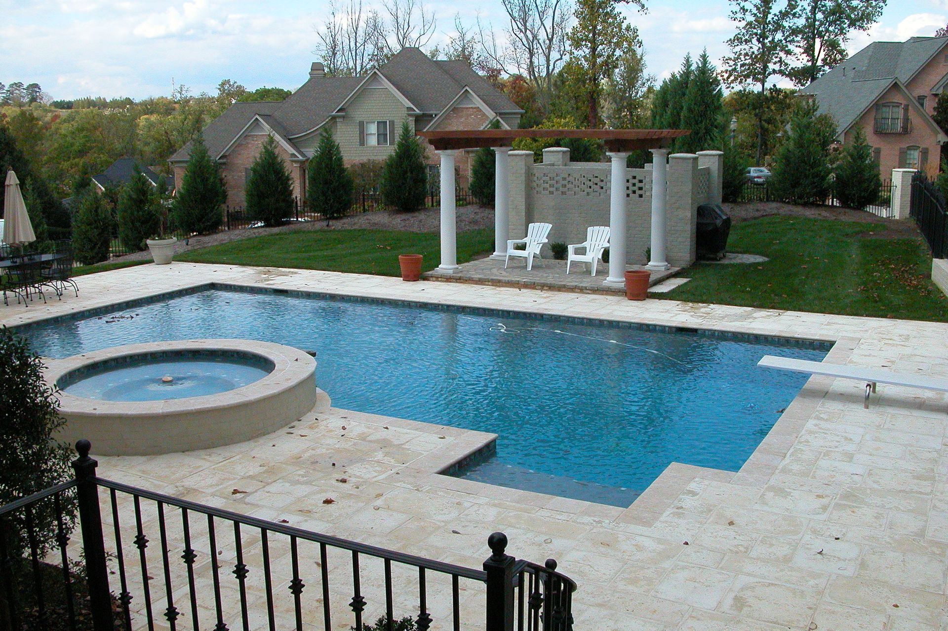 Backyard with rectangular pool, circular hot tub, and white pergola patio area