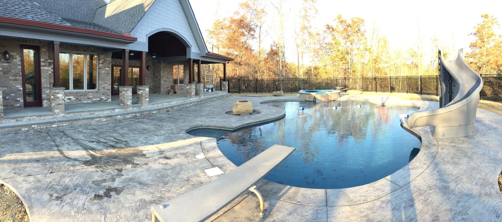 Stone patio with a reflecting pool beside a modern house at sunset