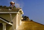 A man is working on the roof of a house.