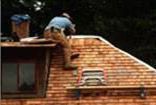 A man is working on the roof of a house.