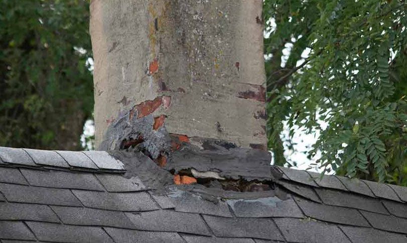 A chimney on top of a roof with a hole in it.