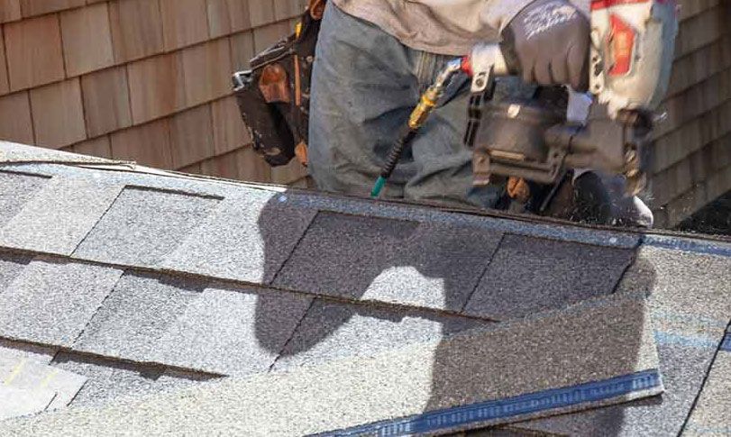 a man is installing roof with shingles