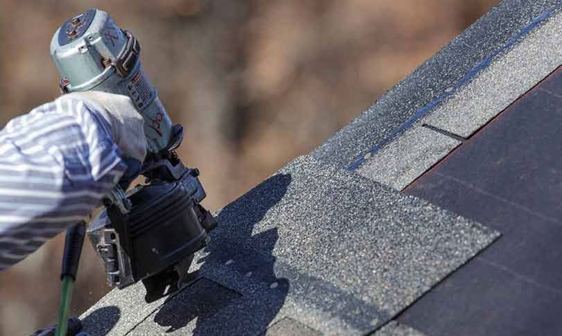 a man is installing slate roof with shingles