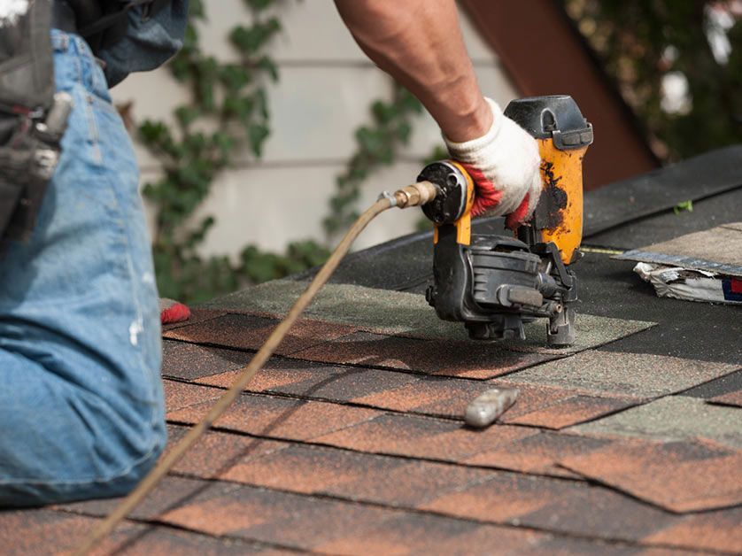 a man is installing roof with shingles