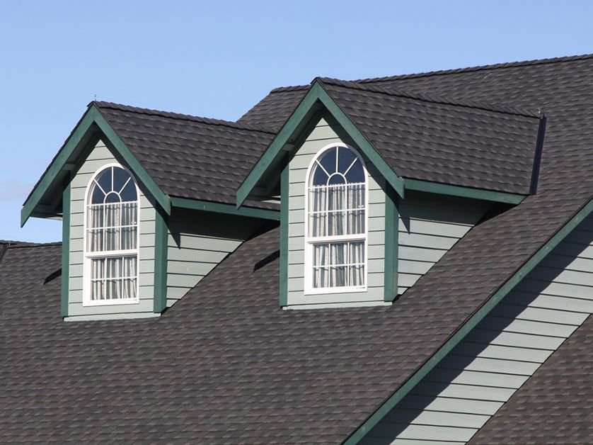 The roof of a house has two windows on it