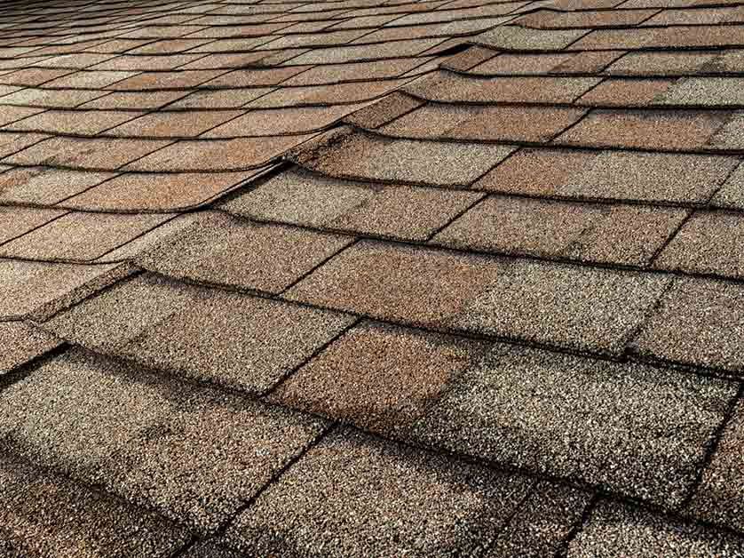 A close up of a roof with shingles that are missing.