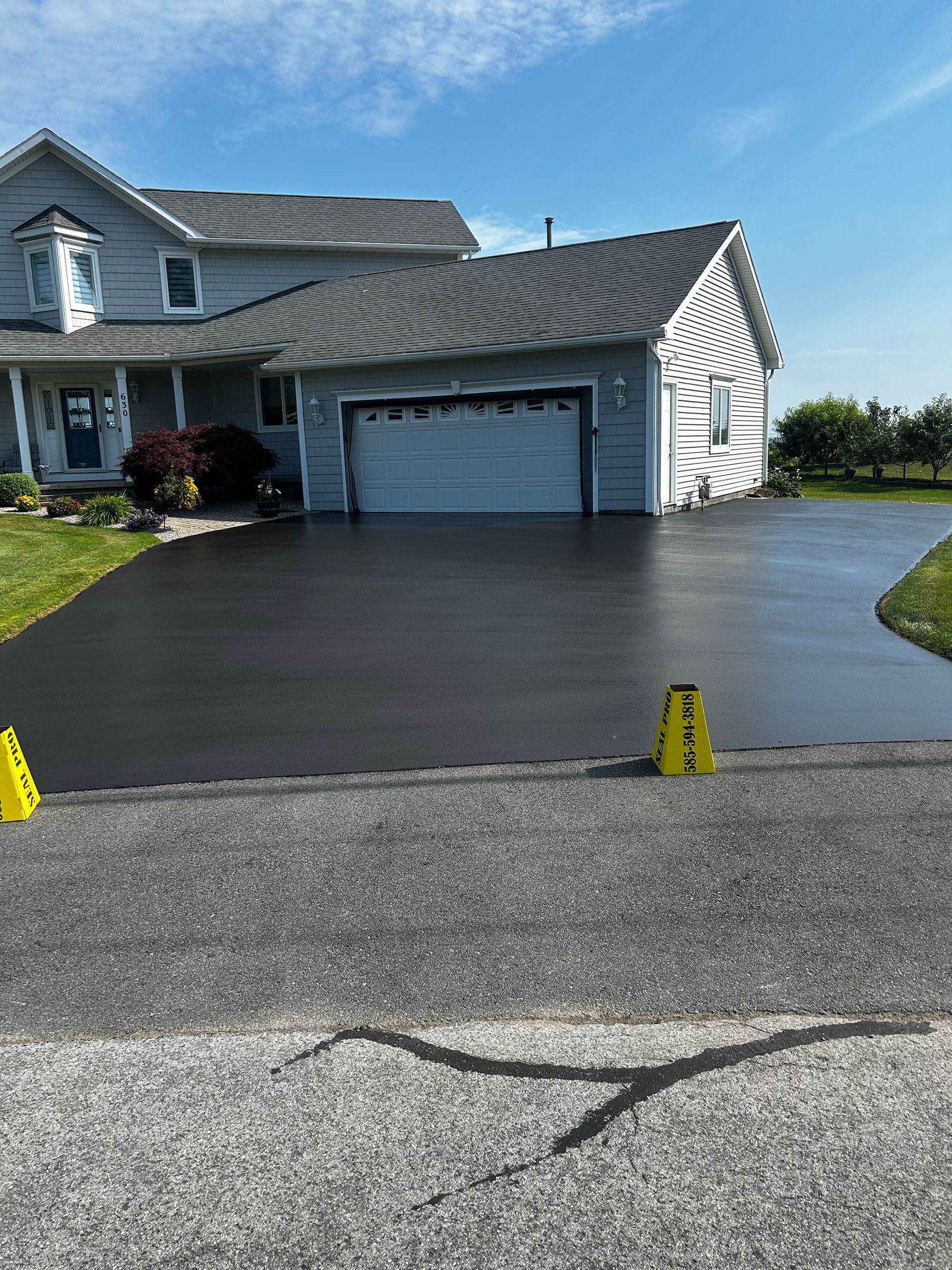 a large house with a black driveway and a yellow caution sign