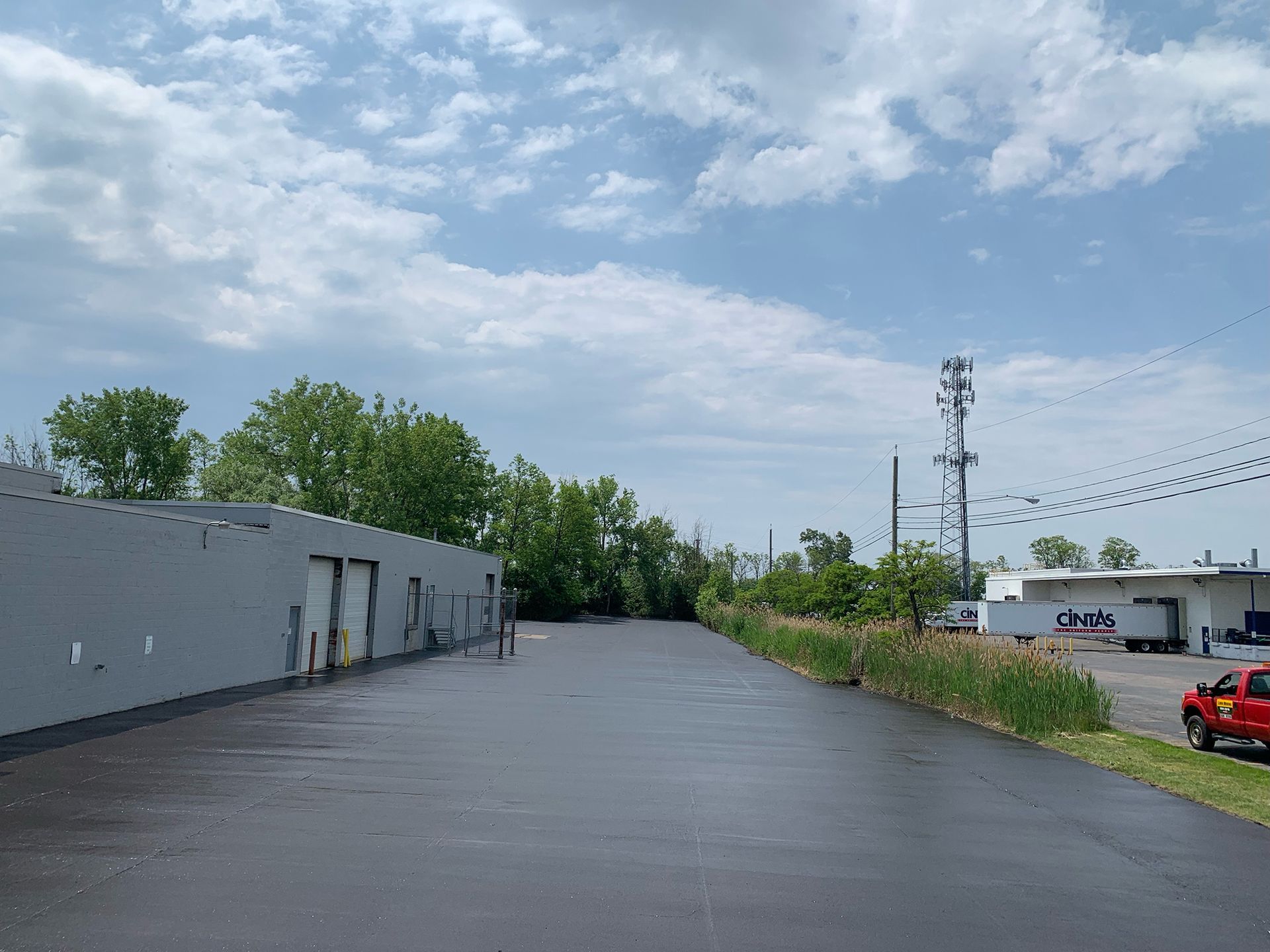 a red car is parked in a parking lot next to a building